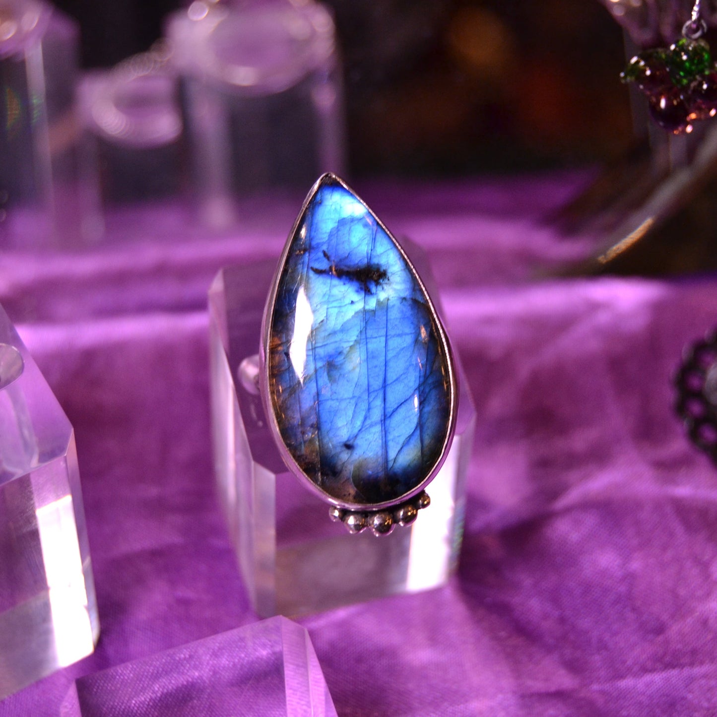 Silver boho handmade ring with blue labradorite pear shaped stone cabachon on a purple background