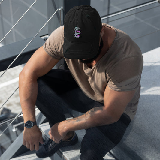 Black adjustable baseball cap featuring an embroidered design of a floral snake motif with the text "FERAL SOUL JEWELLERY." The cap is worn by a man and features a curved brim, combining comfort and alternative fashion style.



