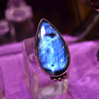 boho silver handmade ring with blue pear shaped stone cabochon on a purple background
